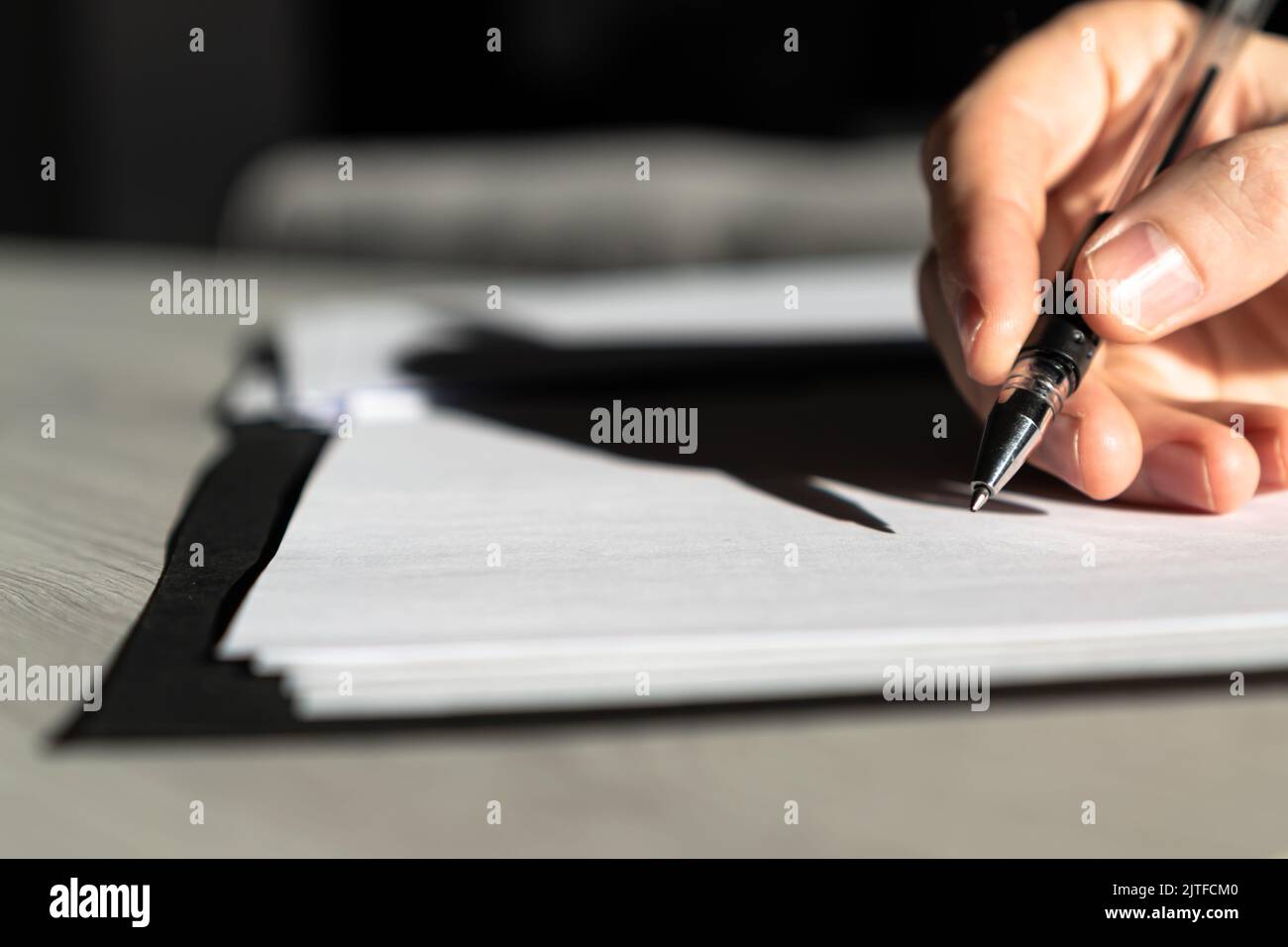 Kaukasische Handsilhouette im Begriff, wichtige Dokumente oder Verträge zu unterzeichnen Stockfoto