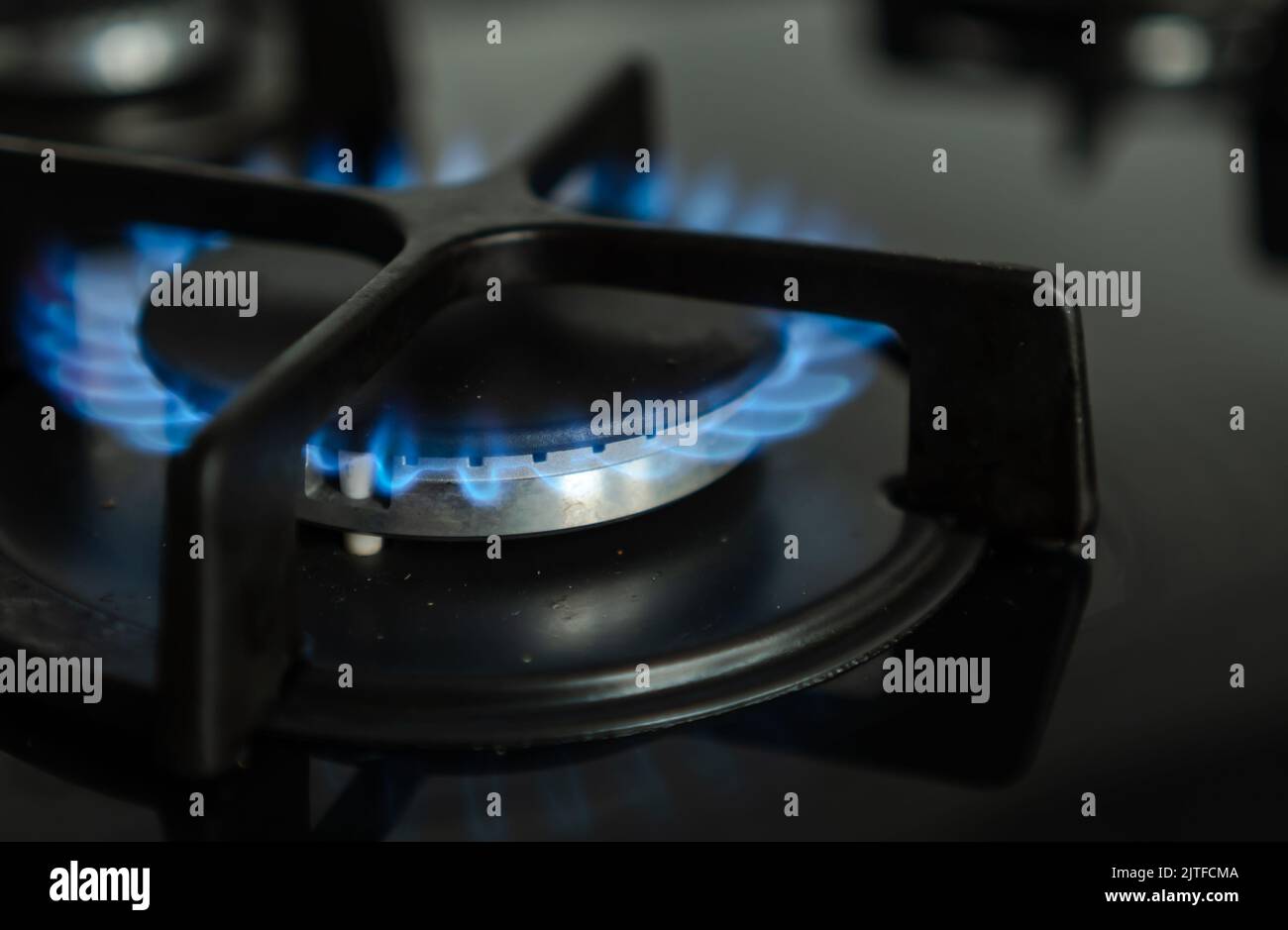 Nahaufnahme der blauen Flamme des Erdgasbrennens in den Brennern einer modernen Küche Stockfoto