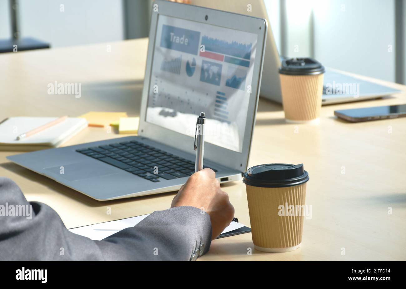 Frau Hand in Business-Anzug mit Stift Schreiben auf Notizbuch mit Laptop Hintergrund im Büro Stockfoto