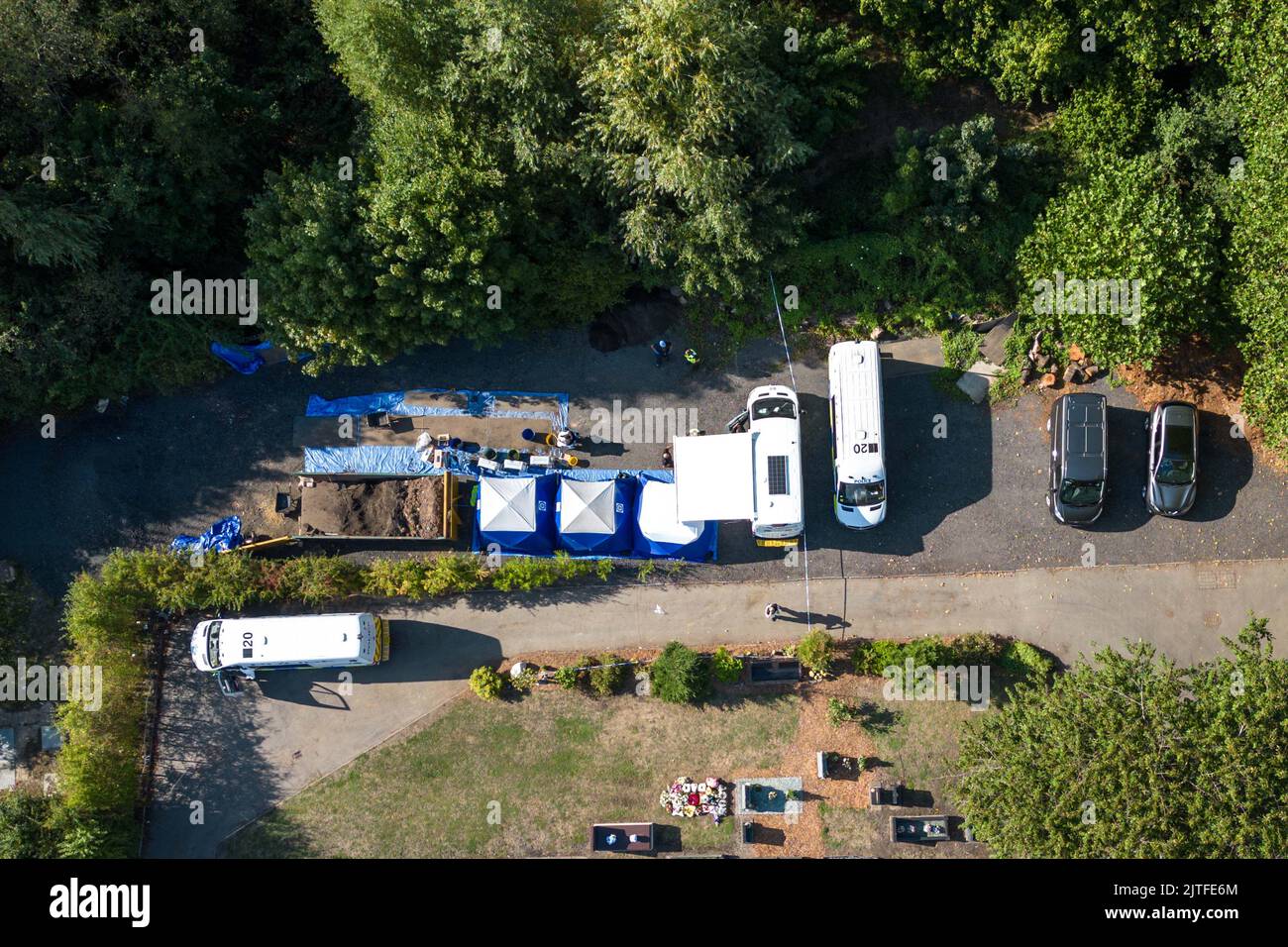 Tipton Cemetery, West Midds August 30. 2022 - die Polizei durchsiebt die Erde von einem sprung, wo am Samstag, dem 27. August, menschliche Überreste auf dem Tipton Cemetery, West Midlands, gefunden wurden. Drei blaue forensische Zelte waren zu sehen, zusammen mit mehreren Polizeiwagen, Forensik-Beamten in weißen Anzügen und einer Kordon am Ende des Friedhofs, in der Nähe des Spielplatzes der Akademie Q3. Ein Sprecher der Polizei von West Midlands sagte: ‘Wir untersuchen, nachdem am Samstagabend (27. August) auf dem Tipton Cemetery in der Alexandra Road menschliche Überreste gefunden wurden. Das Gebiet wurde für weitere Durchsuchungen abgesperrt Stockfoto