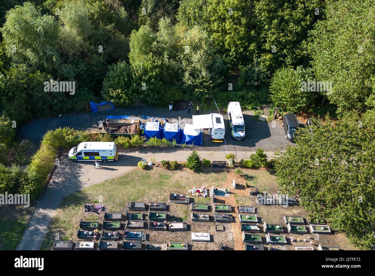 Tipton Cemetery, West Midds August 30. 2022 - die Polizei durchsiebt die Erde von einem sprung, wo am Samstag, dem 27. August, menschliche Überreste auf dem Tipton Cemetery, West Midlands, gefunden wurden. Drei blaue forensische Zelte waren zu sehen, zusammen mit mehreren Polizeiwagen, Forensik-Beamten in weißen Anzügen und einer Kordon am Ende des Friedhofs, in der Nähe des Spielplatzes der Akademie Q3. Ein Sprecher der Polizei von West Midlands sagte: ‘Wir untersuchen, nachdem am Samstagabend (27. August) auf dem Tipton Cemetery in der Alexandra Road menschliche Überreste gefunden wurden. Das Gebiet wurde für weitere Durchsuchungen abgesperrt Stockfoto