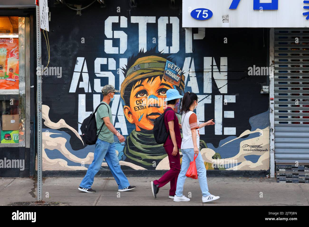 Die Menschen gehen an einem Wandgemälde „Stop Asian Hate“ in Manhattan, Chinatown, vorbei. Das Kunstwerk und die Botschaft wurden von Dragon76, einem japanischen Maler in New York City, gemalt. Stockfoto