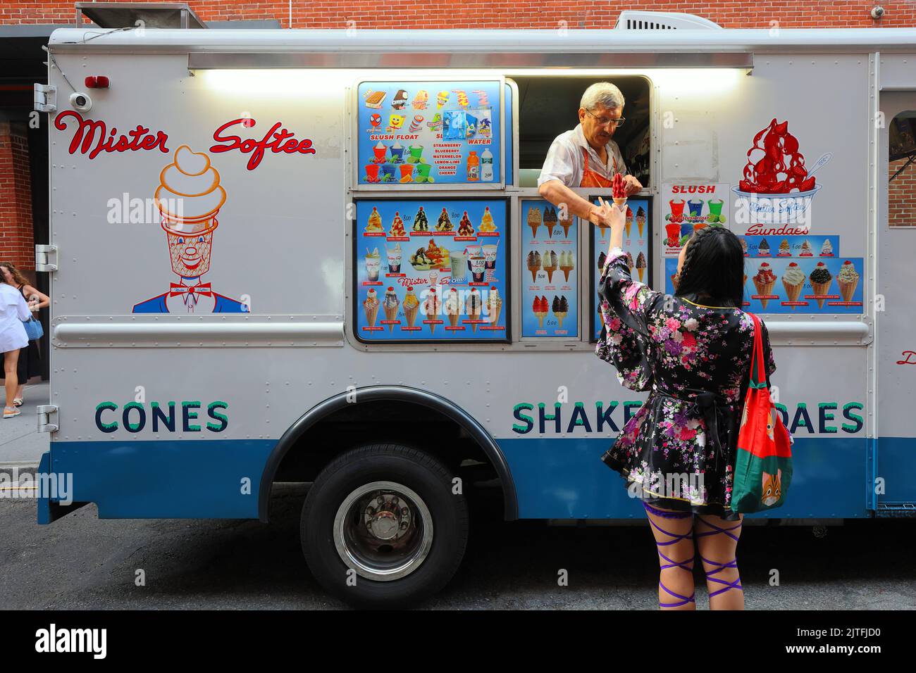 Asiatisch-amerikanischer Kunde bei einem Eisdiele von Mister Softee mit einem asiatisch-amerikanischen Fahrer, New York. Stockfoto