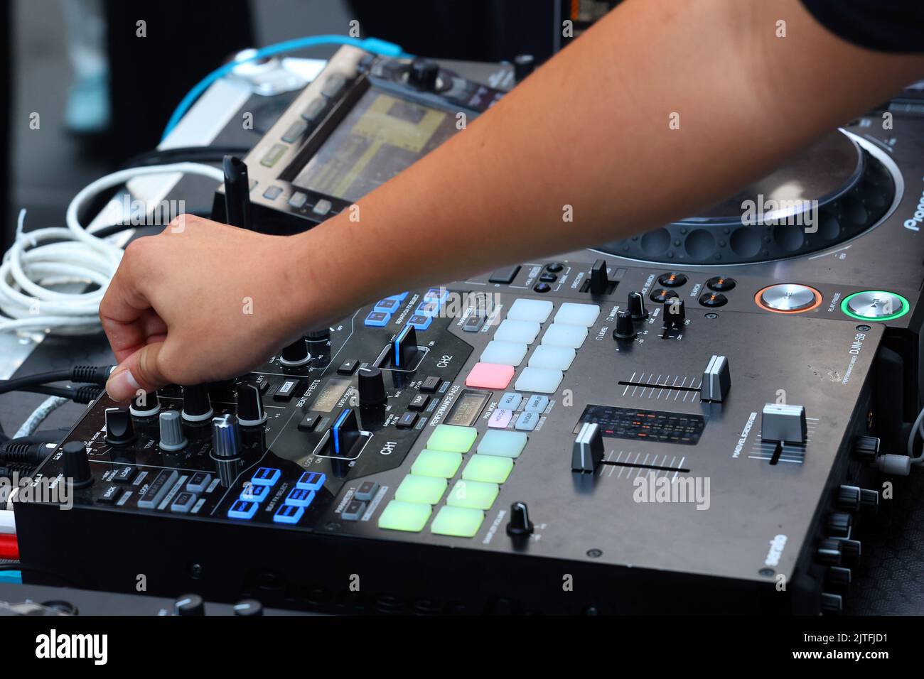 Ein Party-DJ dreht einen Regler auf einem digitalen Pioneer DJM-S9-Mischpult, um die „Hi“-Noten auf einem Musiktitel auf einer Tanzparty anzupassen Stockfoto
