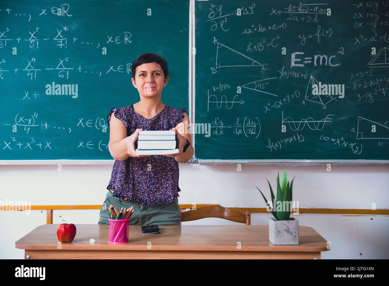 Zurück zur Schule Konzept: Lehrer geben Bücher an ihre Schüler im Klassenzimmer zu Beginn der neuen Schulzeit. Stockfoto