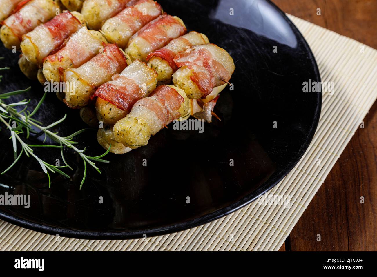 Cassava-Spieße in Speck eingewickelt, Cassava-Medaillon. Stockfoto