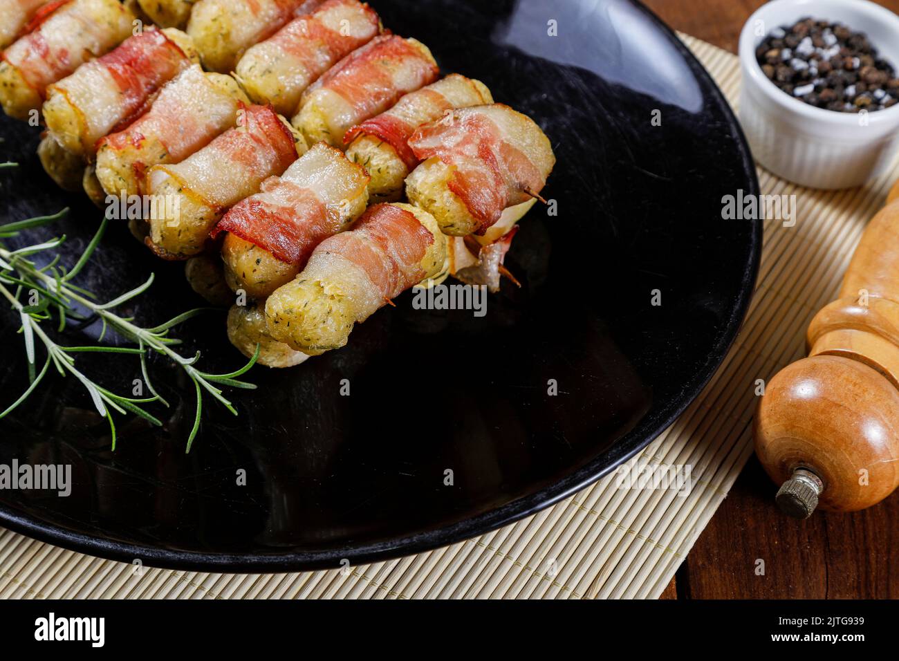 Cassava-Spieße in Speck eingewickelt, Cassava-Medaillon. Stockfoto