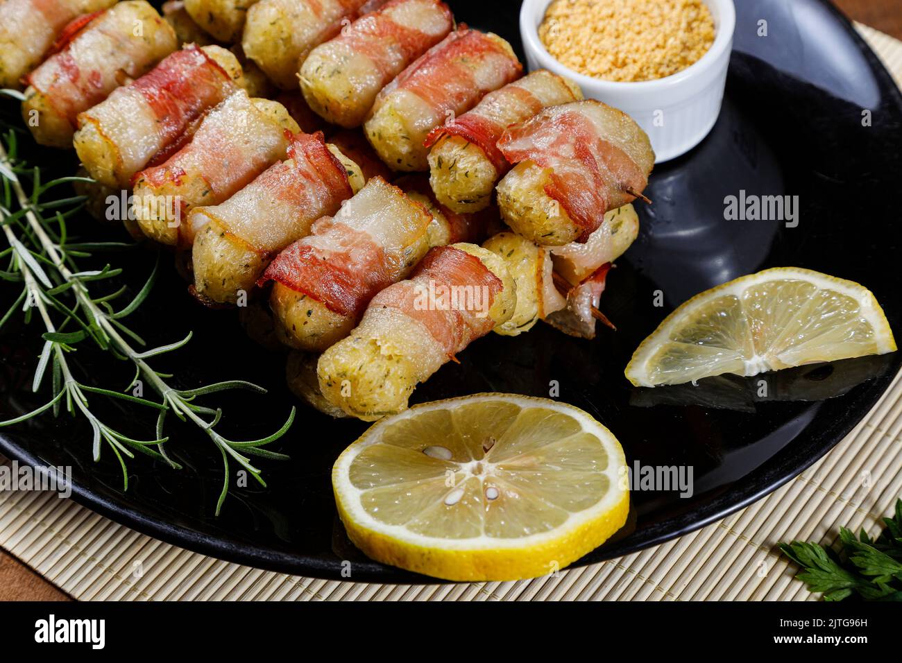 Cassava-Spieße in Speck eingewickelt, Cassava-Medaillon. Stockfoto