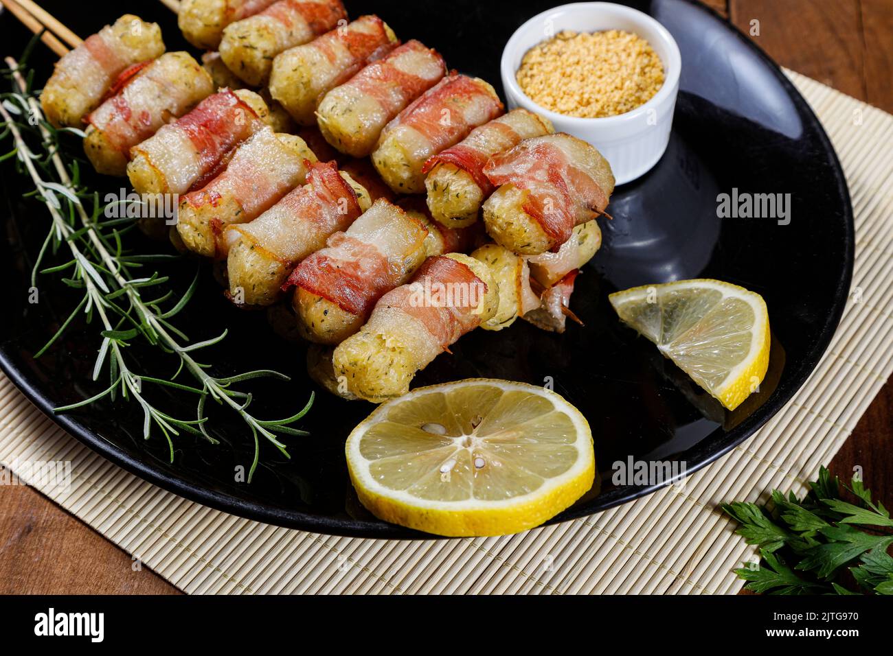 Cassava-Spieße in Speck eingewickelt, Cassava-Medaillon. Stockfoto