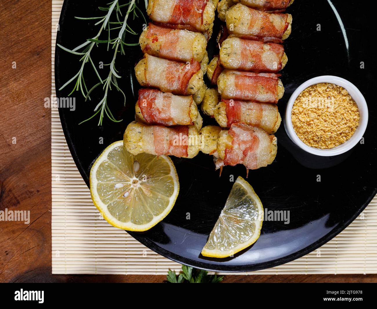 Cassava-Spieße in Speck eingewickelt, Cassava-Medaillon. Stockfoto