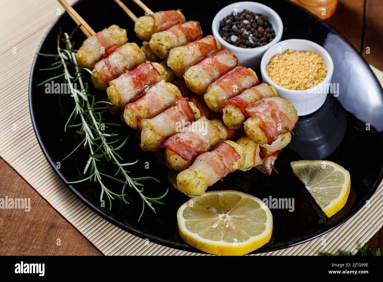 Cassava-Spieße in Speck eingewickelt, Cassava-Medaillon. Stockfoto