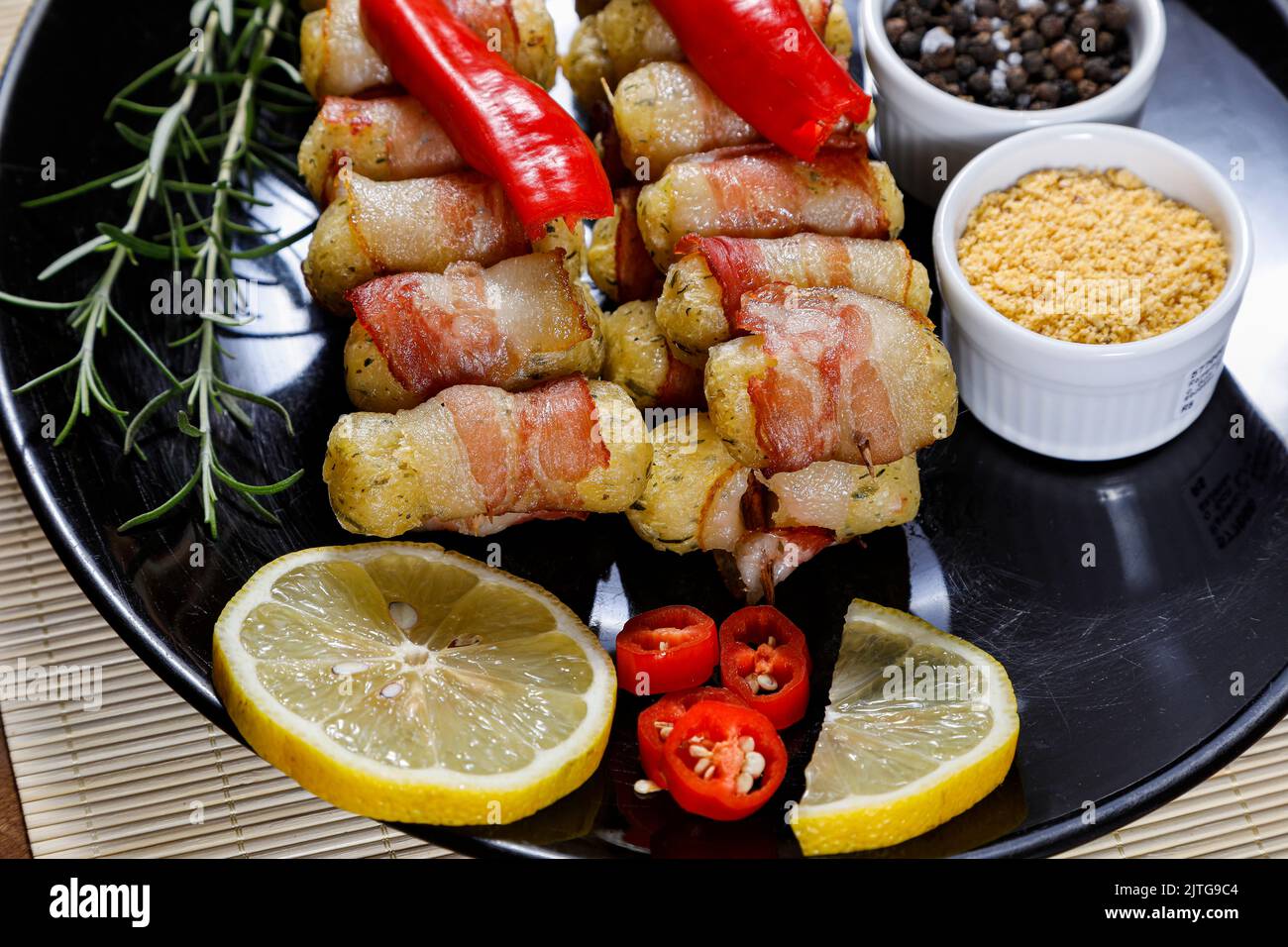 Cassava-Spieße in Speck eingewickelt, Cassava-Medaillon. Stockfoto