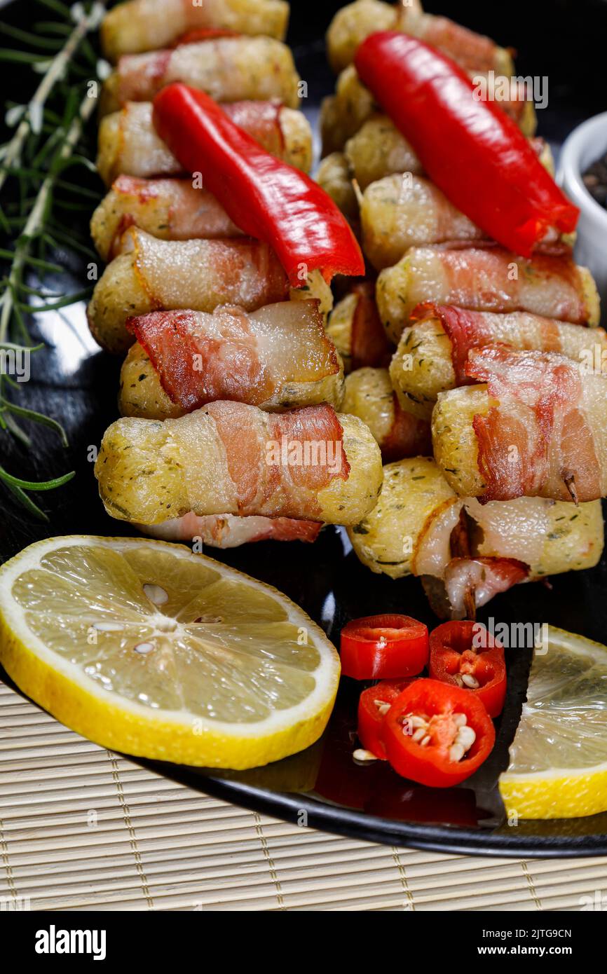 Cassava-Spieße in Speck eingewickelt, Cassava-Medaillon. Stockfoto