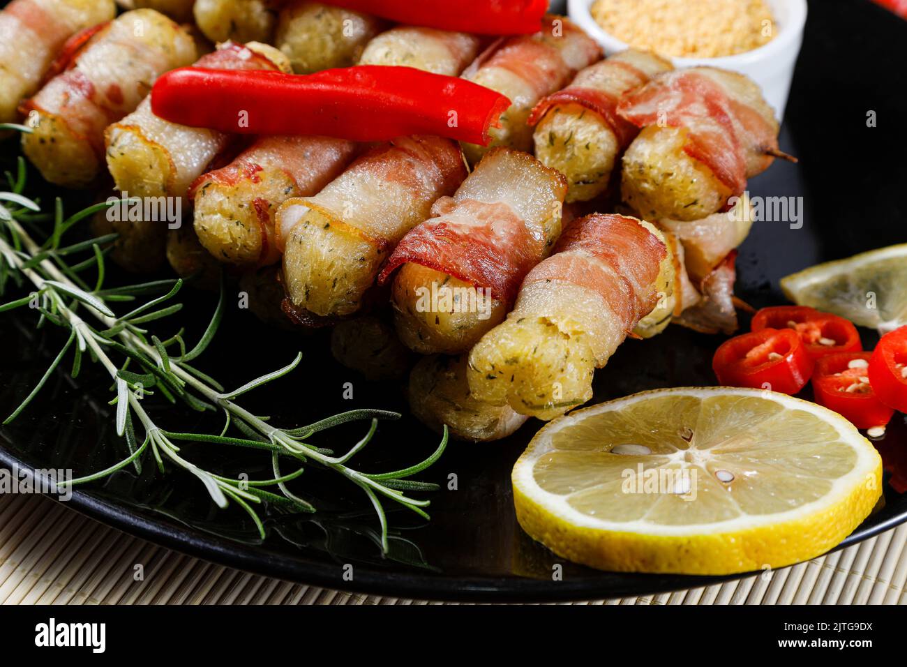 Cassava-Spieße in Speck eingewickelt, Cassava-Medaillon. Stockfoto