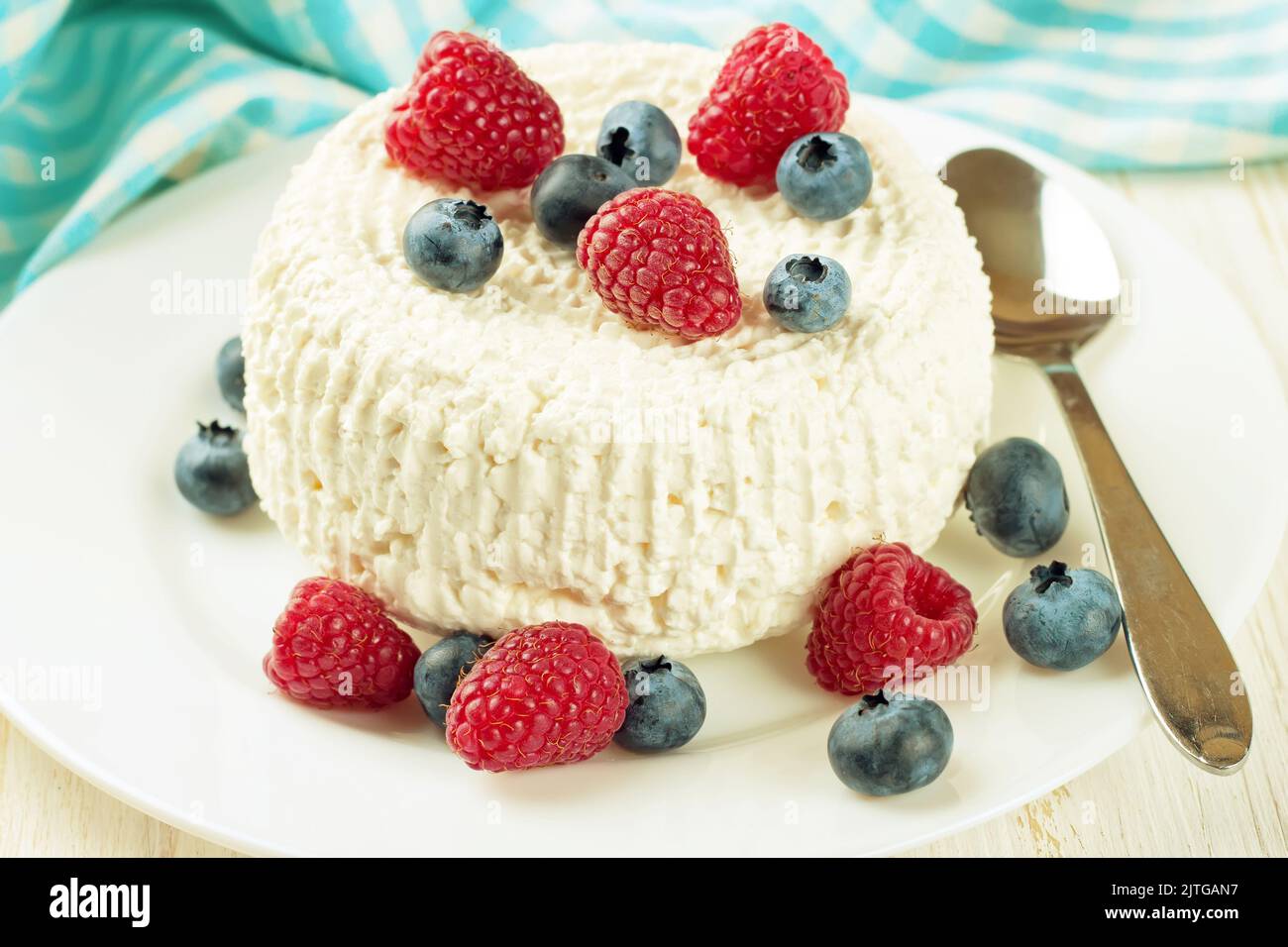 Quark mit Himbeeren und Heidelbeeren auf weißem Teller. Milchprodukte, gesunde Lebensmittel. Stockfoto