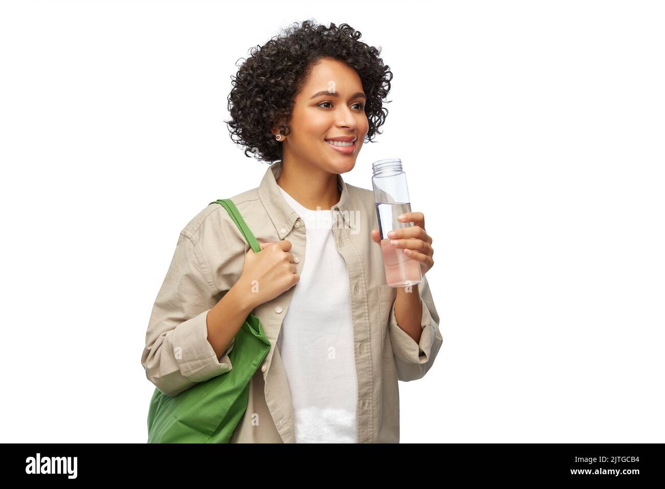 Glückliche Frau mit Wasser in Glasflasche und Shopper Stockfoto