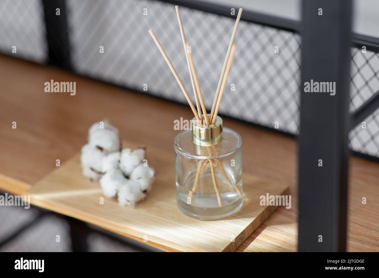 Duftschilfdiffusor und Baumwollblumen auf dem Regal Stockfoto