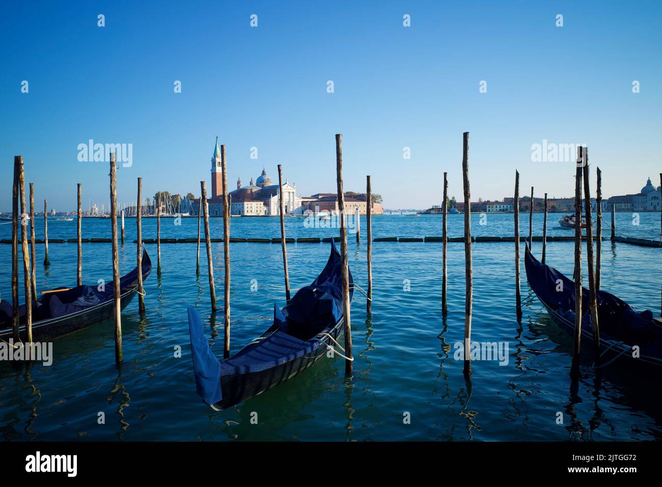 Gondeln in einem Kanal von Venedig. Die Kirche San Giorgio Maggiore ist von weitem zu sehen. Stockfoto