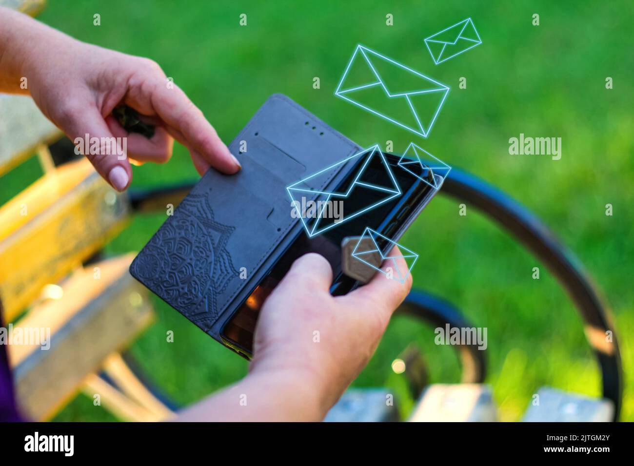 Unschärfe-Effekte bei Nahaufnahme von weiblichen Händen, die sich außerhalb des Telefons berühren. Frau in lila Bluse mit Smartphone, während sie auf einer Bank im Park sitzt. Co Stockfoto
