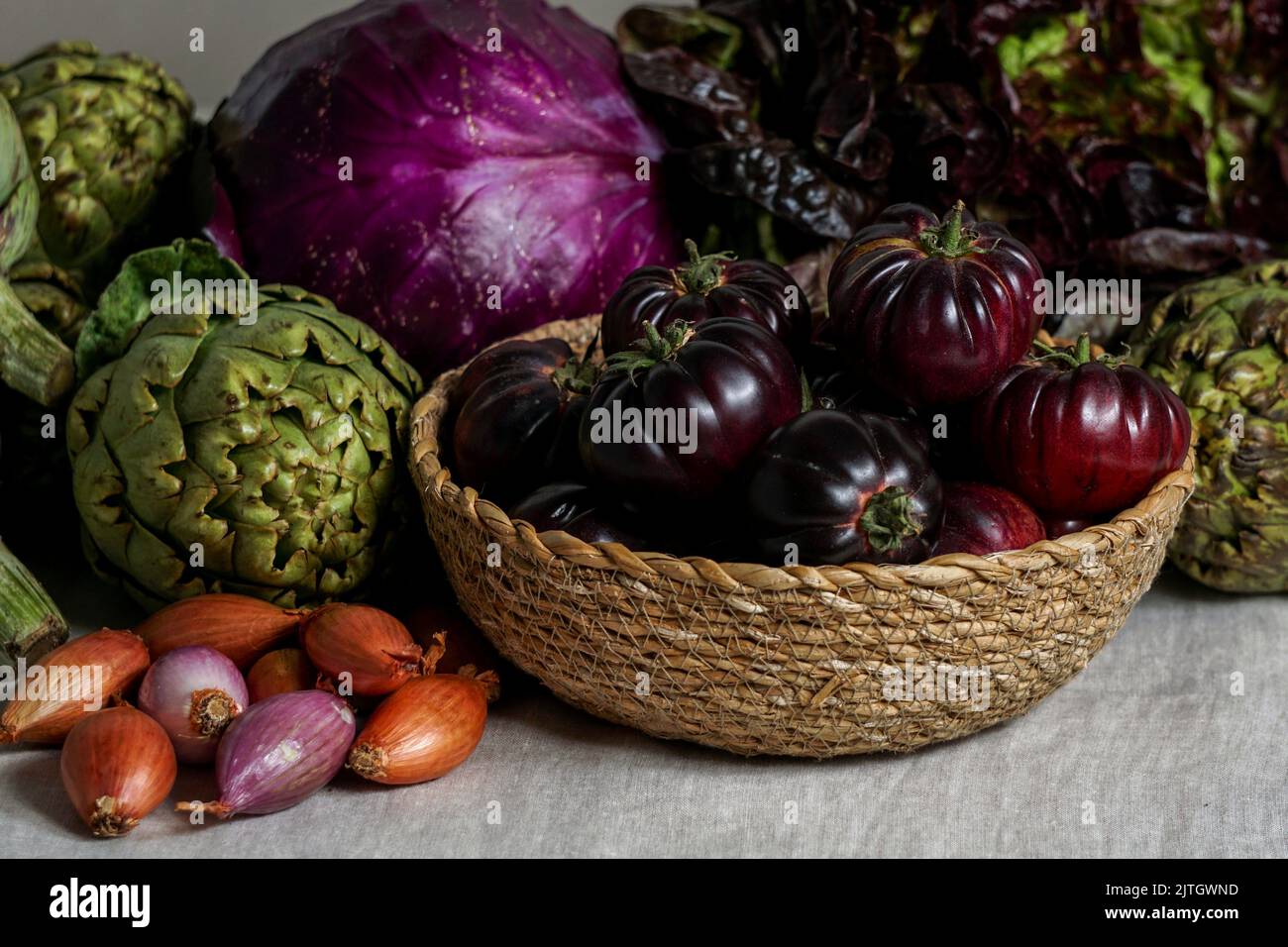 Violettes Gemüse auf dem Holzhintergrund, violette Artischocke, Tomaten, Oniones, Salat Stockfoto