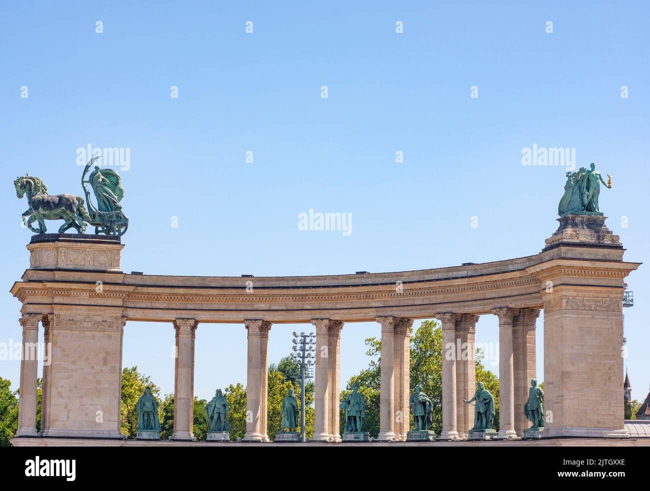 Denkmäler auf dem Heldenplatz in der Nähe des Parlamentshauses in Budapest zeigen große Säulen und Statuen mit blauem Himmel darüber. Helden auf dem Pferderücken werden dargestellt. Stockfoto