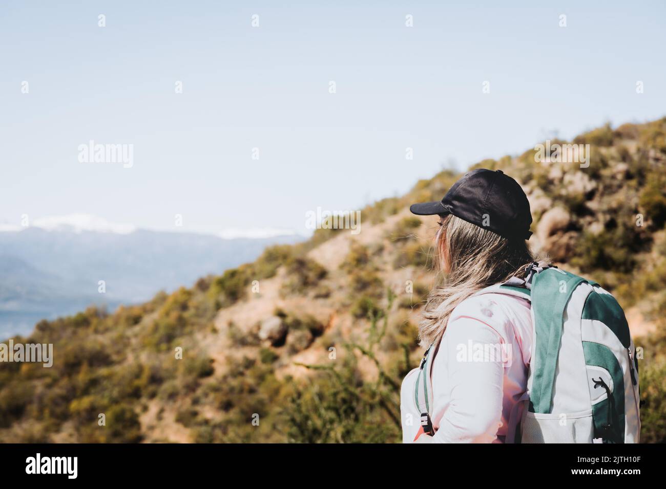 Rückansicht junge latein plus size Frau mit Rucksack auf, Blick von der Spitze eines Hügels betrachten Stockfoto