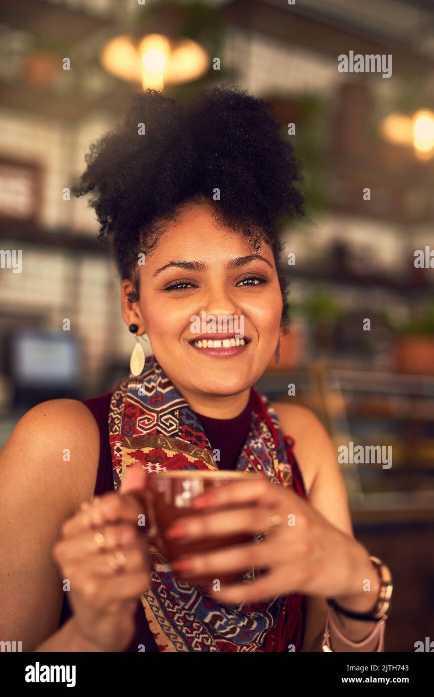 Es ist immer Zeit, eine schnelle Tasse Kaffee zu fangen. Porträt einer attraktiven jungen Frau, die in einem Café eine Tasse Kaffee genießt. Stockfoto