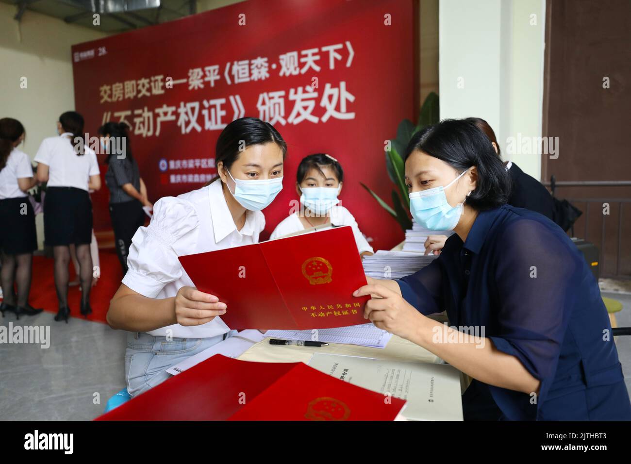 CHONGQING, CHINA - 30. AUGUST 2022 - Hauskäufer (2. R) und Mitarbeiter prüfen in einem neuen Gebäude in Chongqing, CH, die Schutzzertifikate Stockfoto