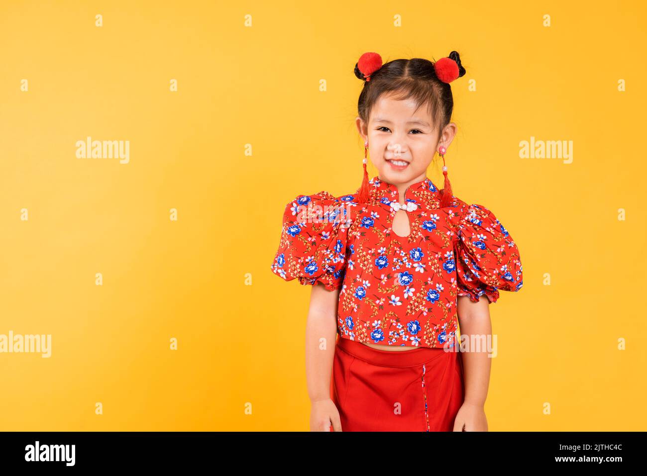 Happy Asian Chinese kleines Mädchen lächeln trägt roten Cheongsam, Portrait Kinder in traditionellen Kleid mit Gruß Geste Feier für Chinesisch New Stockfoto