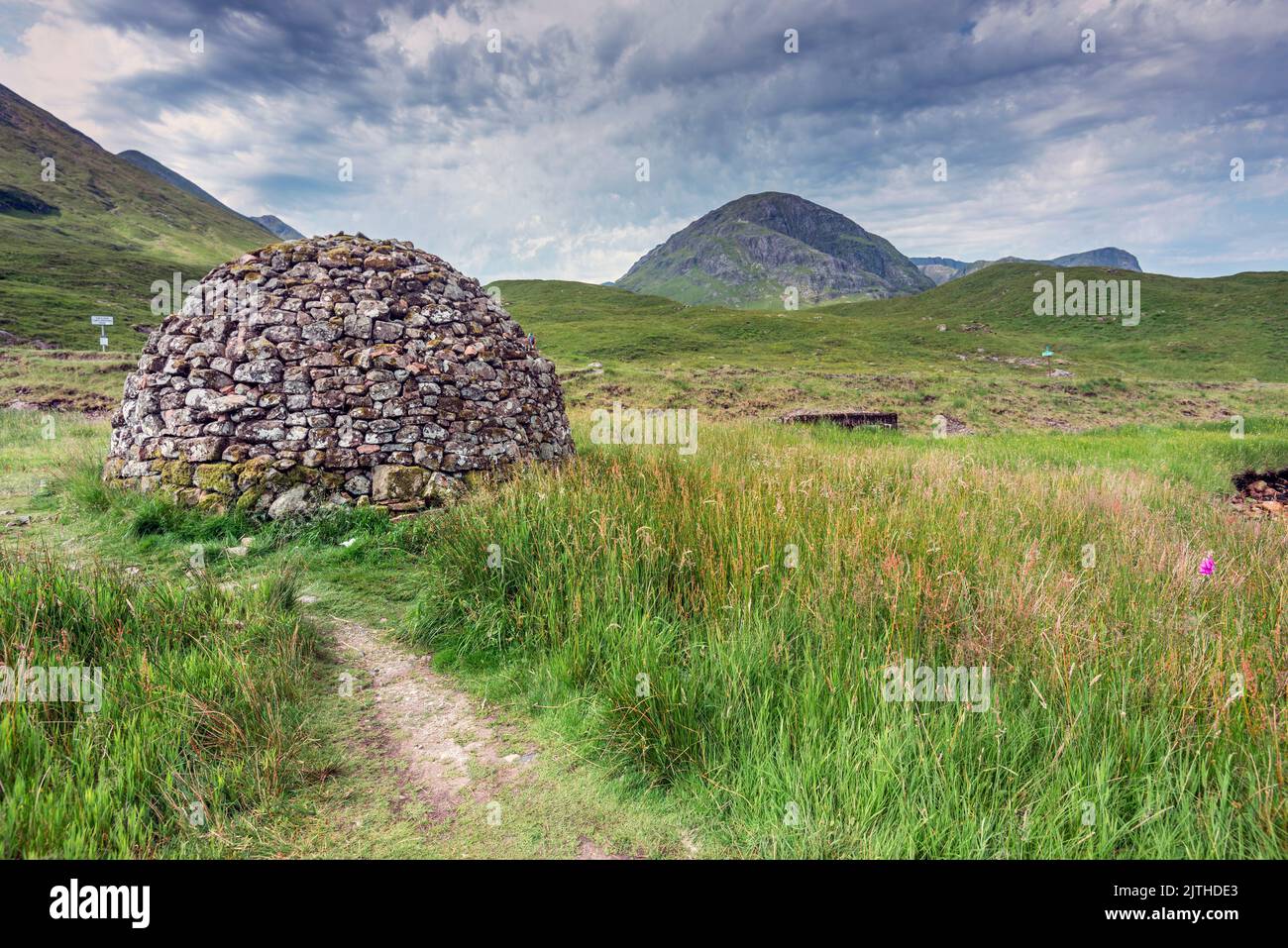 Wunderschöne kuppelförmige Konstruktion, gebaut aus nahe gelegenen Steinen, einst als Särge für die Menschen des alten Schottland verwendet, sitzt zwischen grünem Sommerrasen Stockfoto