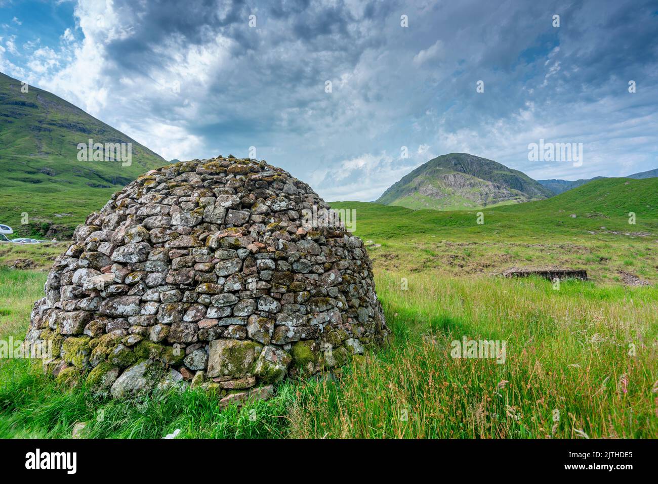 Wunderschöne kuppelförmige Konstruktion, gebaut aus nahe gelegenen Steinen, einst als Särge für die Menschen des alten Schottland verwendet, sitzt zwischen grünem Sommerrasen Stockfoto