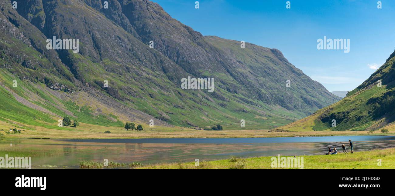 Clen coe,Lochaber,Schottland,Vereinigtes Königreich-August 22 2022: Im Glen Coe Tal genießen junge Familien den Blick über den Loch, der durch das dramatische miniaturisiert wird Stockfoto