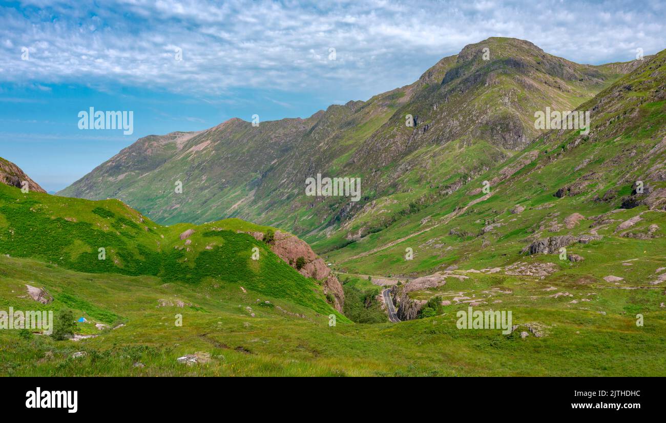 Schöne, Bereich der Highlands, bedeckt mit grünem Sommerrasen, blauer Himmel über. Die A82 Straße schlängelt sich zwischen der herrlichen Landschaft, beliebt bei Touristen Stockfoto