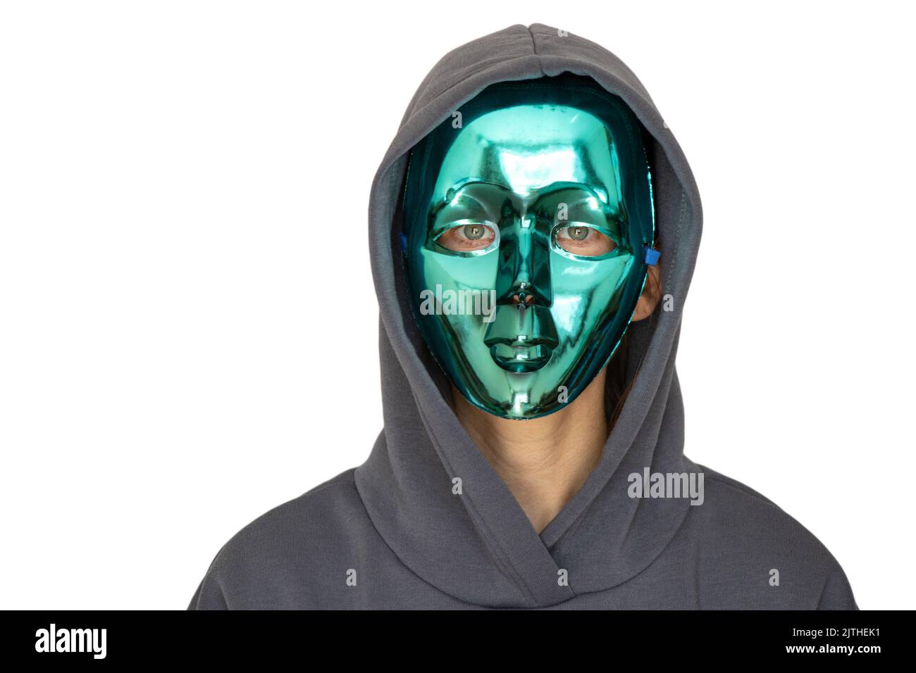 Ein Mädchen in einer Vollmaske aus Kunststoff und in einer Kapuze auf einem isolierten Hintergrund, Anonymität, versteckt ihr Gesicht Stockfoto