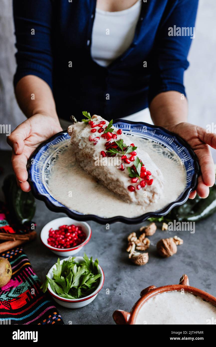 mexikanische Frau Kochen Chiles en nogada Rezept mit Poblano Chili und Zutaten, traditionelles Gericht in Mexiko Stockfoto