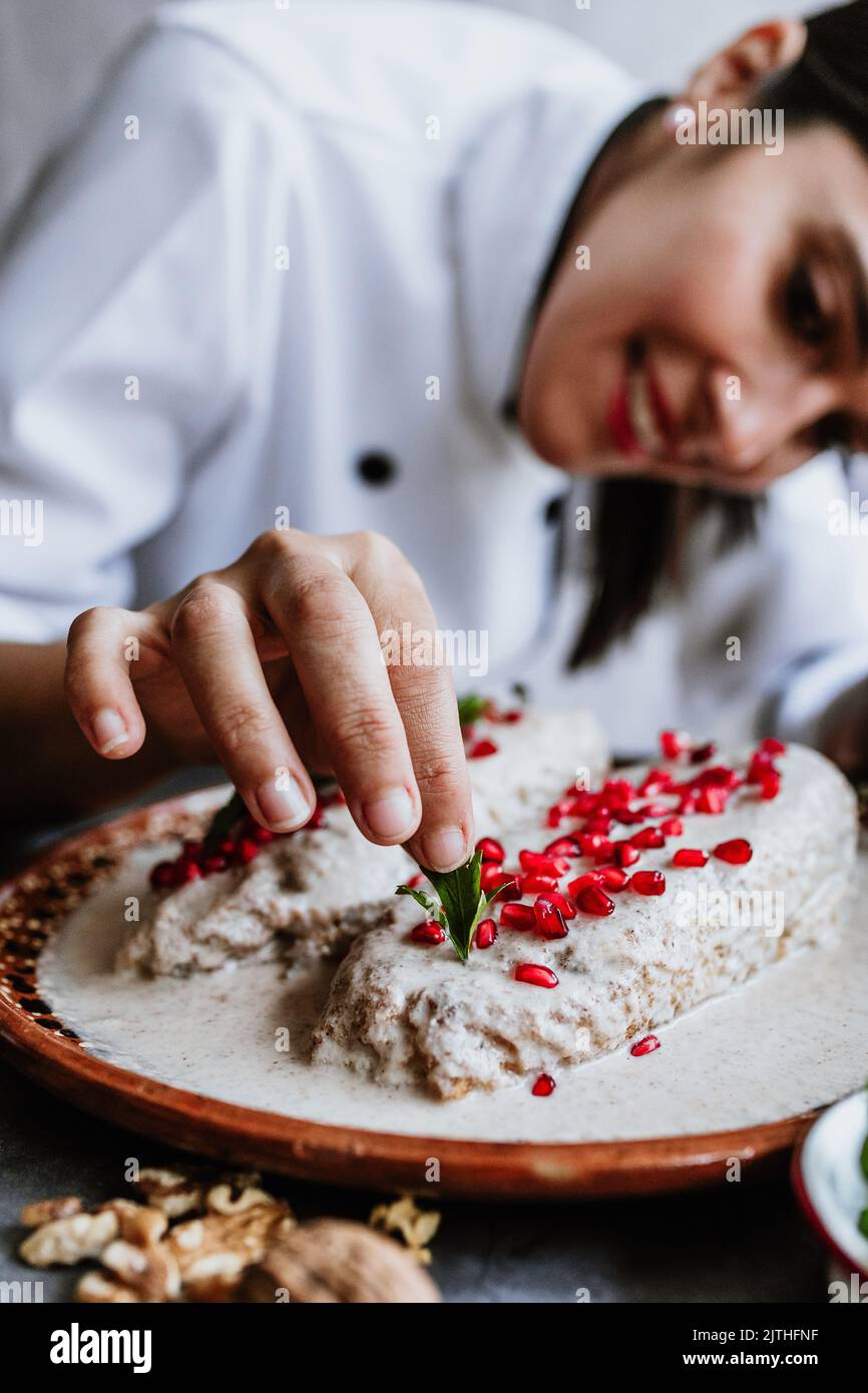 Kochen mexikanische Chilies en nogada Rezept von Frau Chef Hände mit Poblano Chili und Zutaten, traditionelles Gericht in Mexiko Stockfoto
