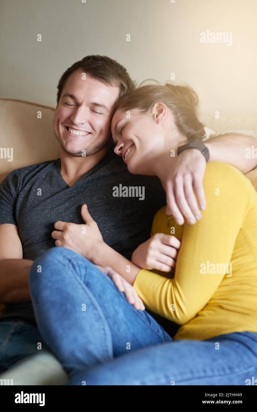 Im viel mehr ich, wenn ich mit dir bin. Ein liebevolles Paar, das sich zu Hause auf der Couch kuschelt. Stockfoto