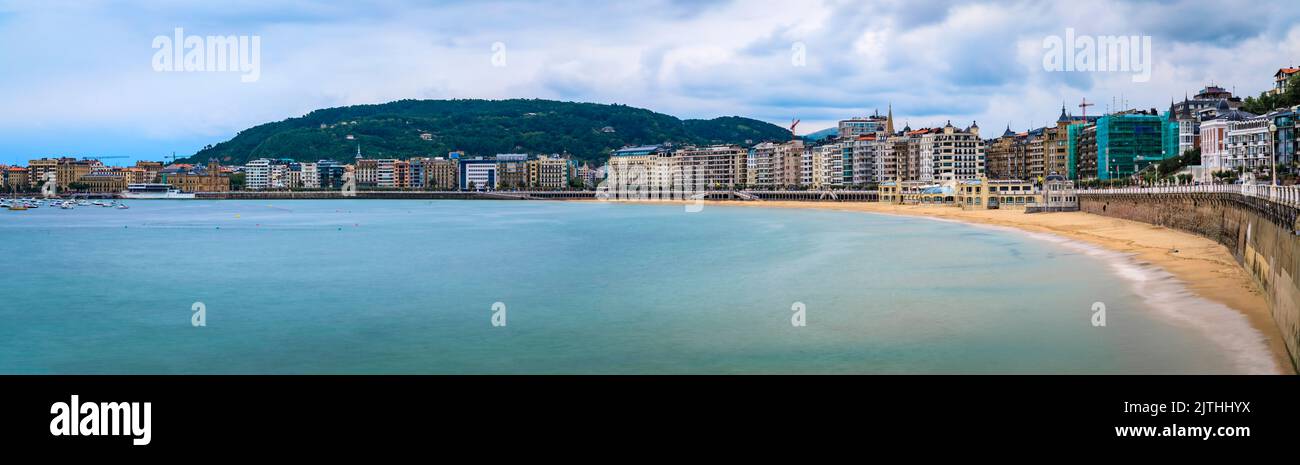 Panorama der Bucht von La Concha und Strand in San Sebastian Donostia mit der Stadtküste und Hotels am Wasser, das Baskenland, Spanien, Langzeitbelichtung Stockfoto