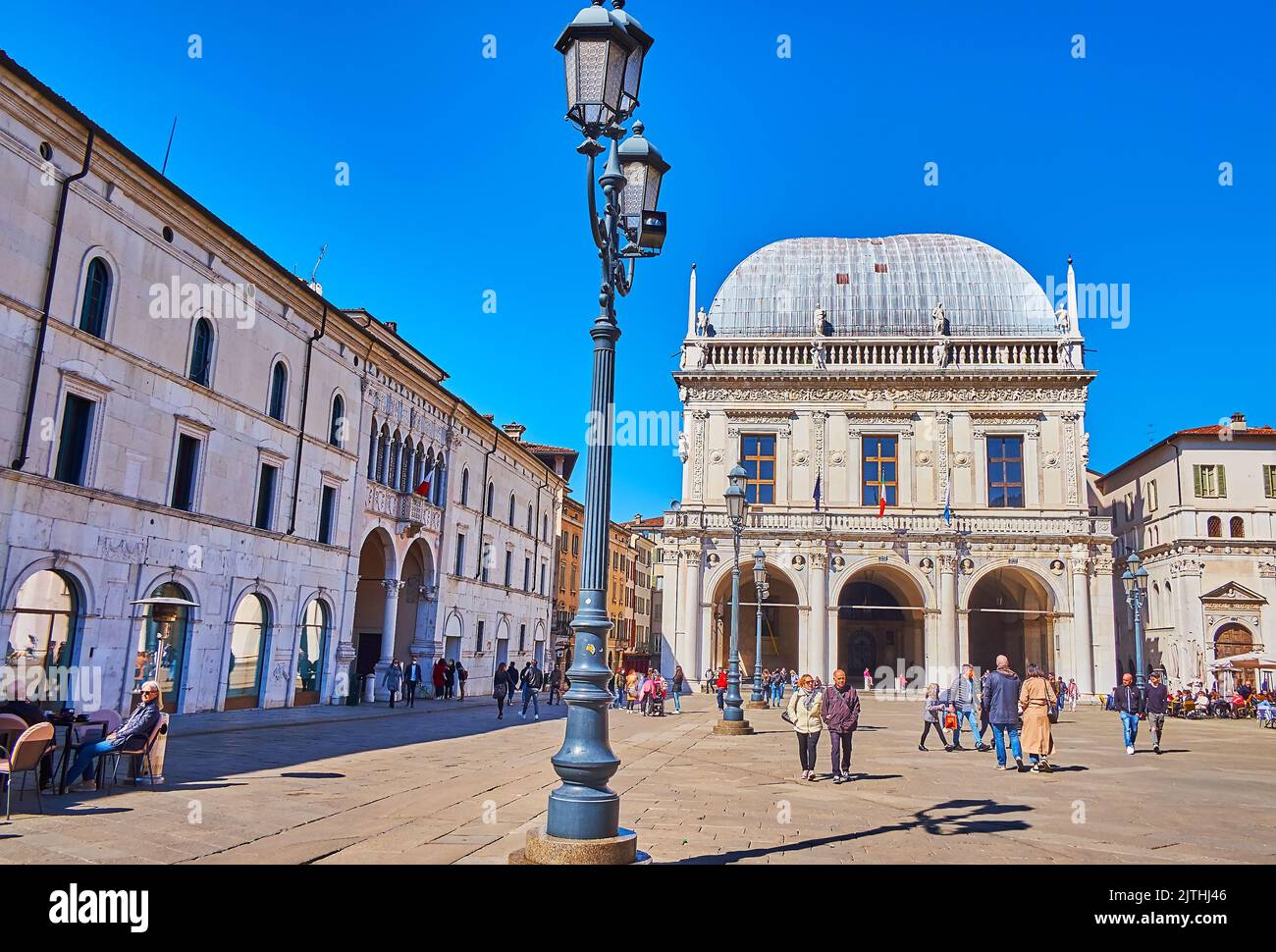 BRESCIA, ITALIEN - 10. APRIL 2022: Die alte Straßenlaterne und der elegante Palazzo della Loggia, der sich auf dem Piazza della Loggia auf AP befindet Stockfoto