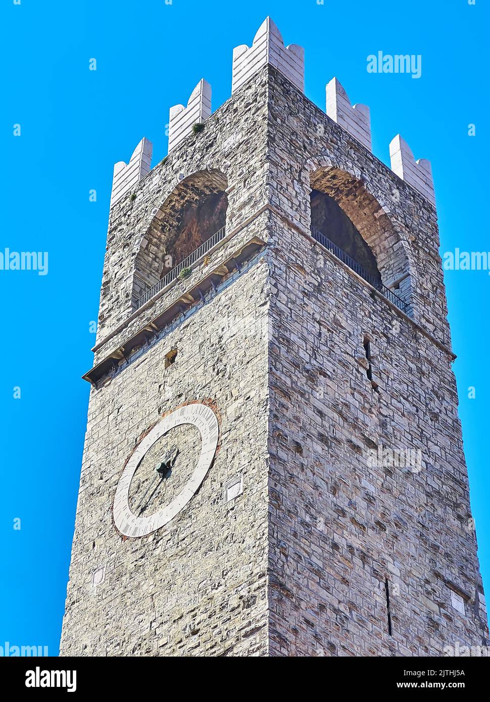 Der hohe Steinturm Torre del pegol mit gewölbter Terrasse, Zinnen und Uhr an der Wand, Palazzo Broletto, Brescia, Lombardei, Italien Stockfoto