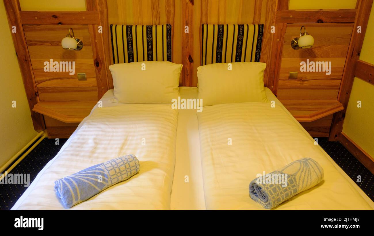 Schlafzimmer für Gäste mit Doppelbetten im Landhaus in Holzmühlen und dem Boden, aus der Nähe. Stockfoto