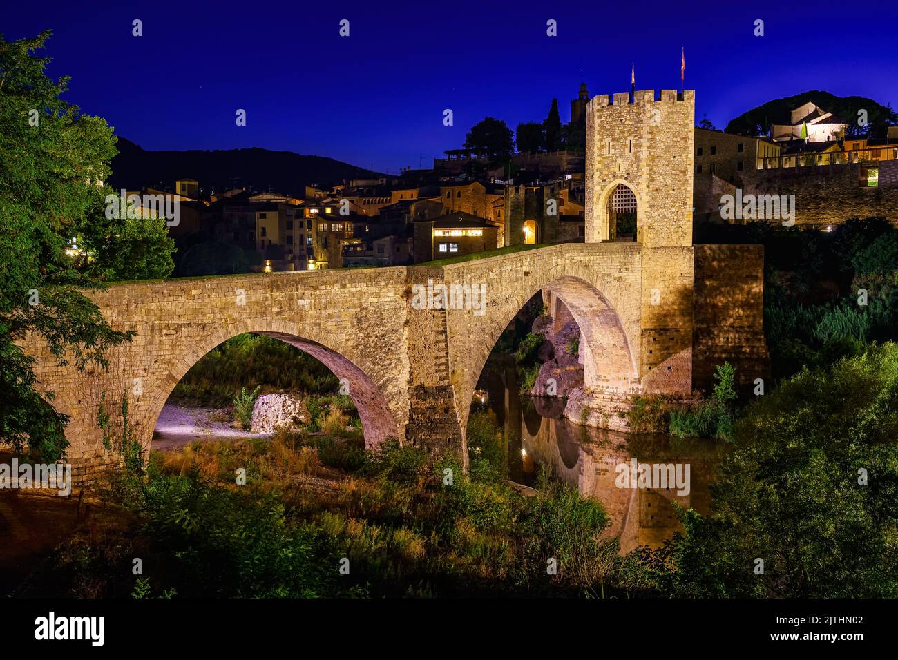 Mittelalterliche Brücke, die den Fluss in der alten Stadt Besalu bei Nacht, Gerona, Spanien überquert. Stockfoto