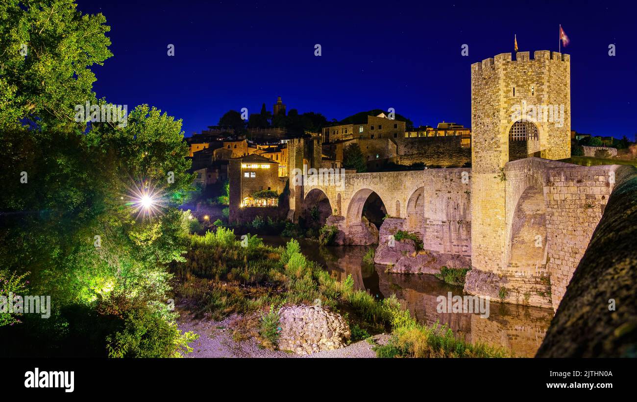 Mittelalterliche Brücke, die den Fluss in der alten Stadt Besalu bei Nacht, Gerona, Spanien überquert. Stockfoto