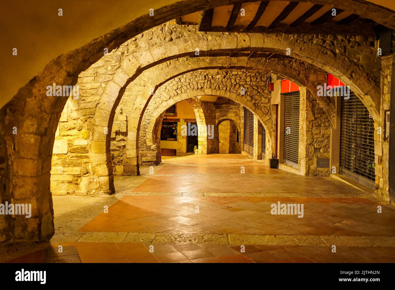 Steinbögen in den Kellern der mittelalterlichen Gebäude der Altstadt von Besalu, Girona, Spanien. Stockfoto