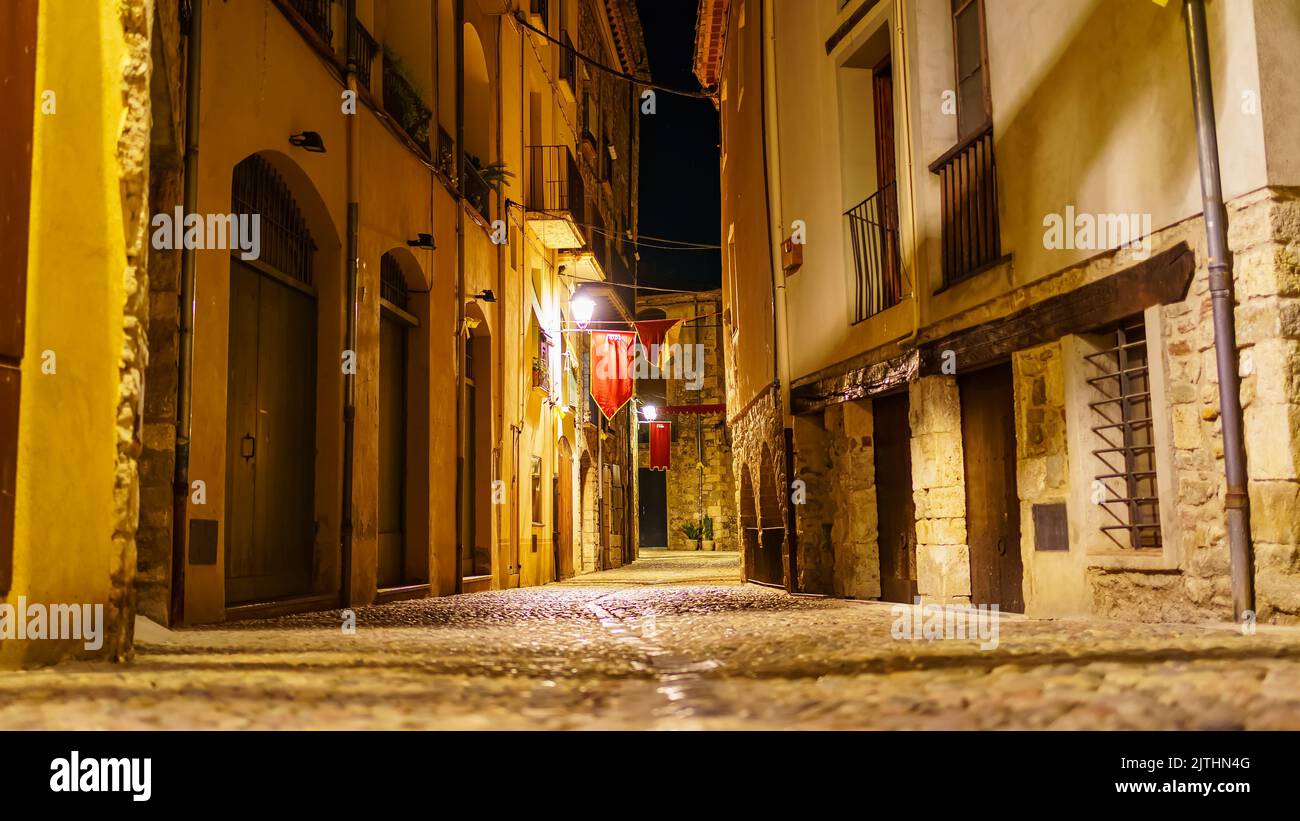 Malerische Gasse mit mittelalterlichen Steinhäusern bei Nacht in der Stadt Besalu, Girona, Katalonien. Stockfoto