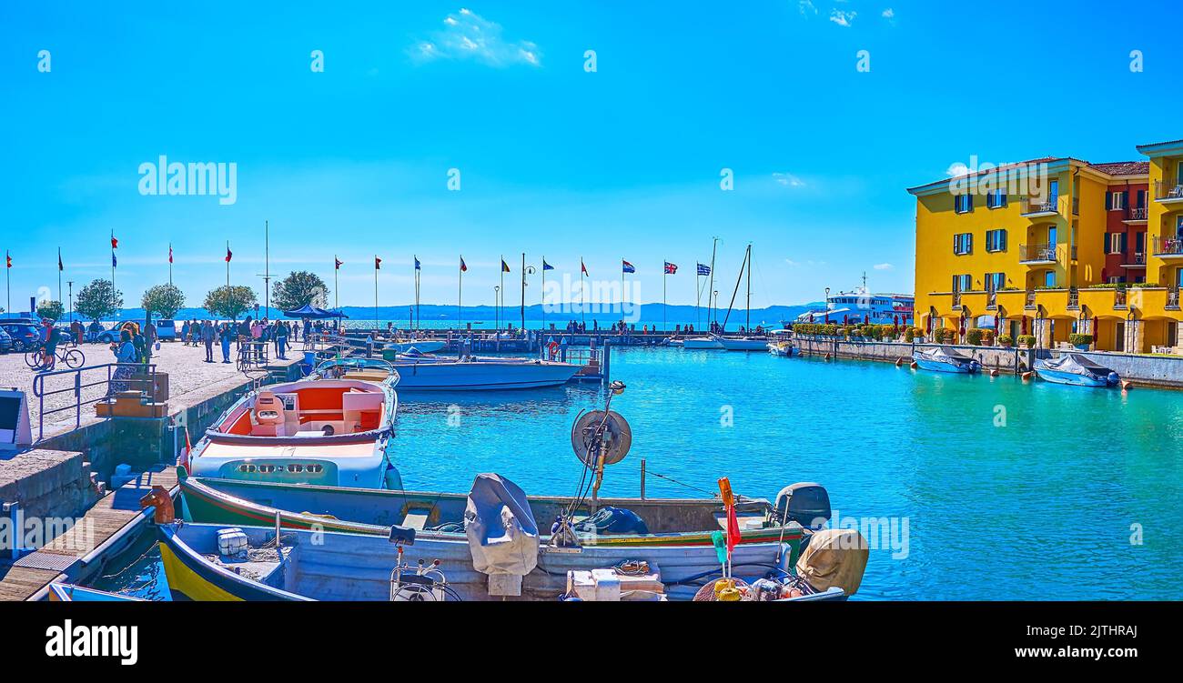 Panoramablick auf den Yachthafen mit den farbigen Fischerei- und Touristenbooten, Sirmione, Lombardei, Italien Stockfoto