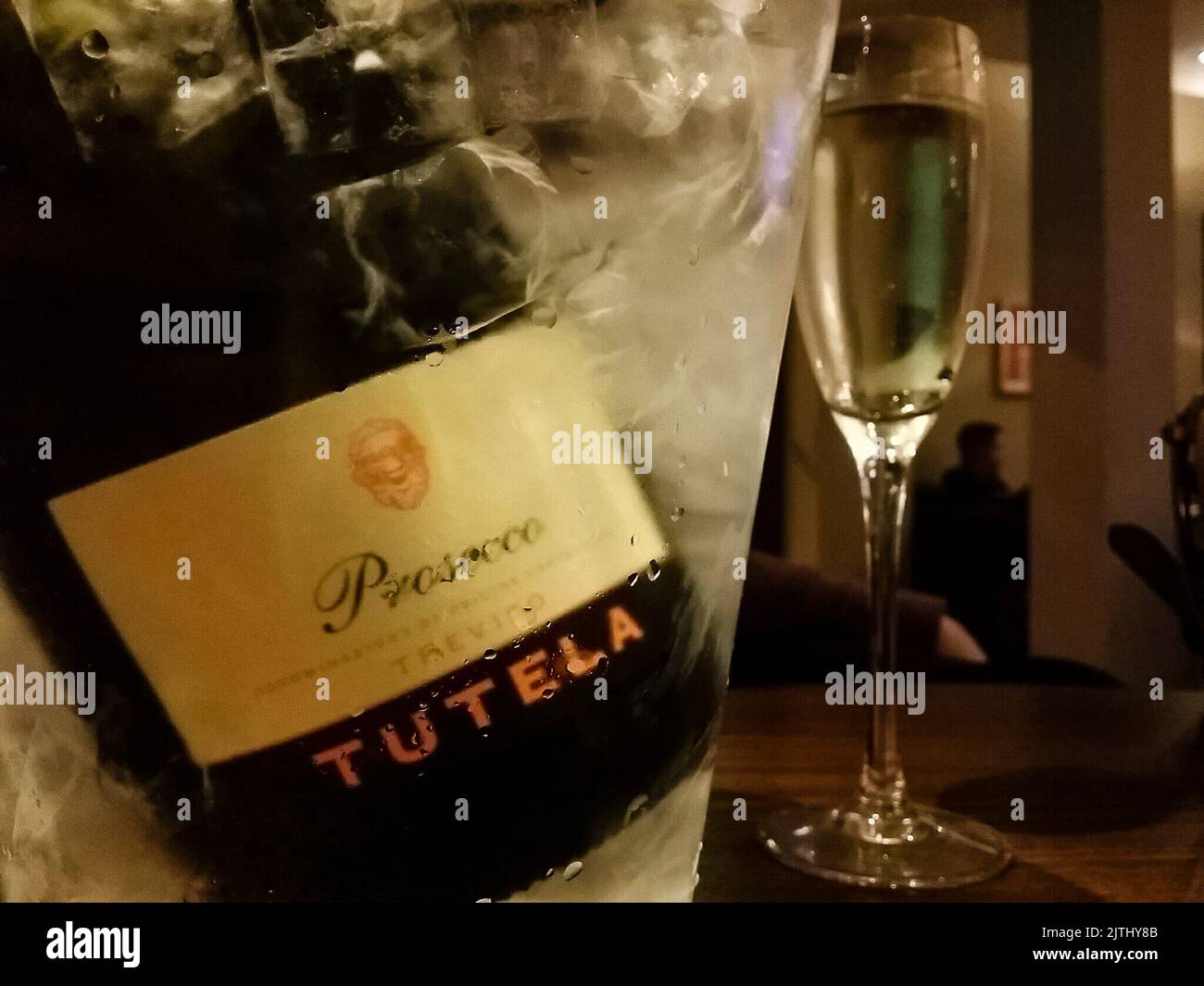 Eine Flasche Tutela Prosecco in einem Eimer Eis mit Sektgläsern in einem Hotelzimmer Stockfoto