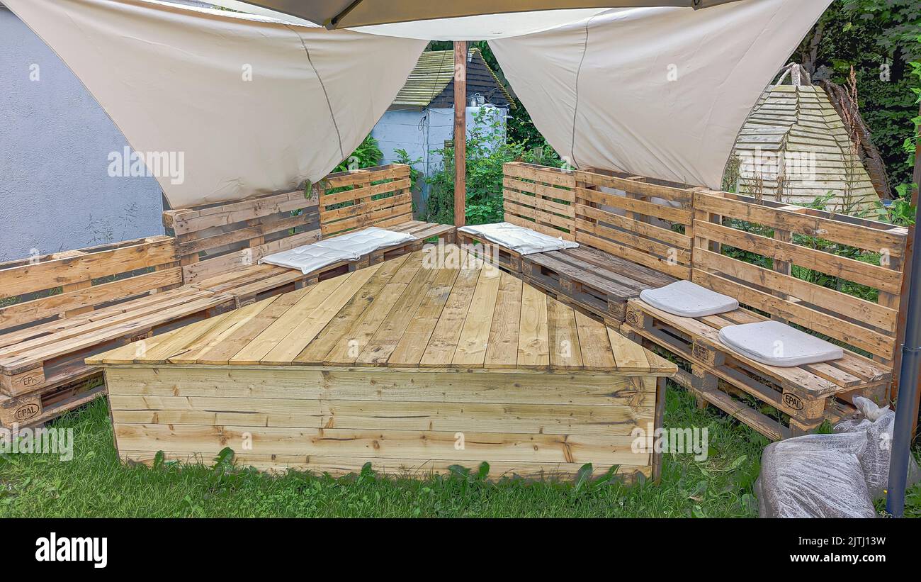 Terrassentisch und Bänke aus Paletten mit einem Leinendach Stockfoto