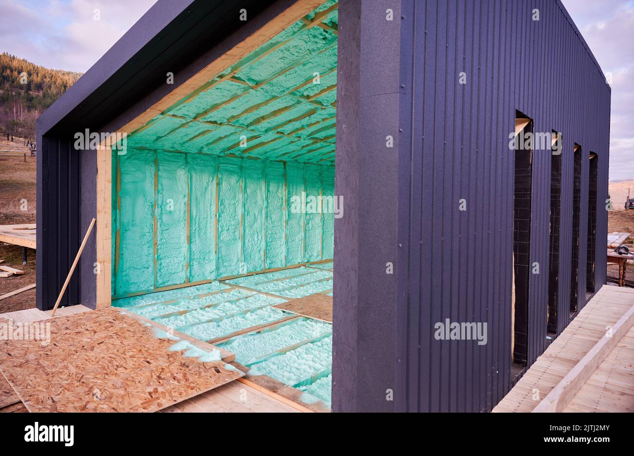 Holzrahmenhaus im skandinavischen Stil, wärmeisoliert mit Polyurethanschaum. Bau- und Isolierkonzept. Stockfoto