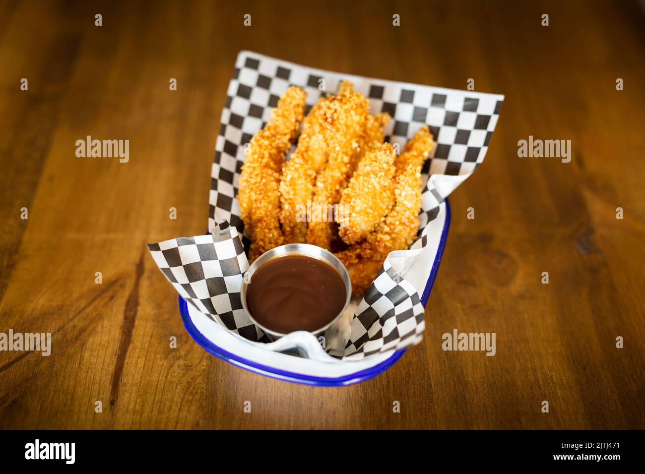 Hähnchenfinger mit Ketchup-Sauce auf einem Teller auf einem Holztisch Stockfoto